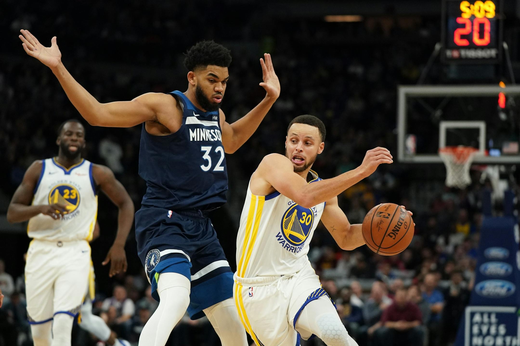 Golden State Warriors guard Stephen Curry (30) took the ball around Minnesota Timberwolves center Karl-Anthony Towns (32) as he drove to the basket in overtime.