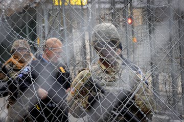 Military and security around downtown watched as protesters marched after the Derek Chauvin case went to the jury at the Hennepin Government Center on