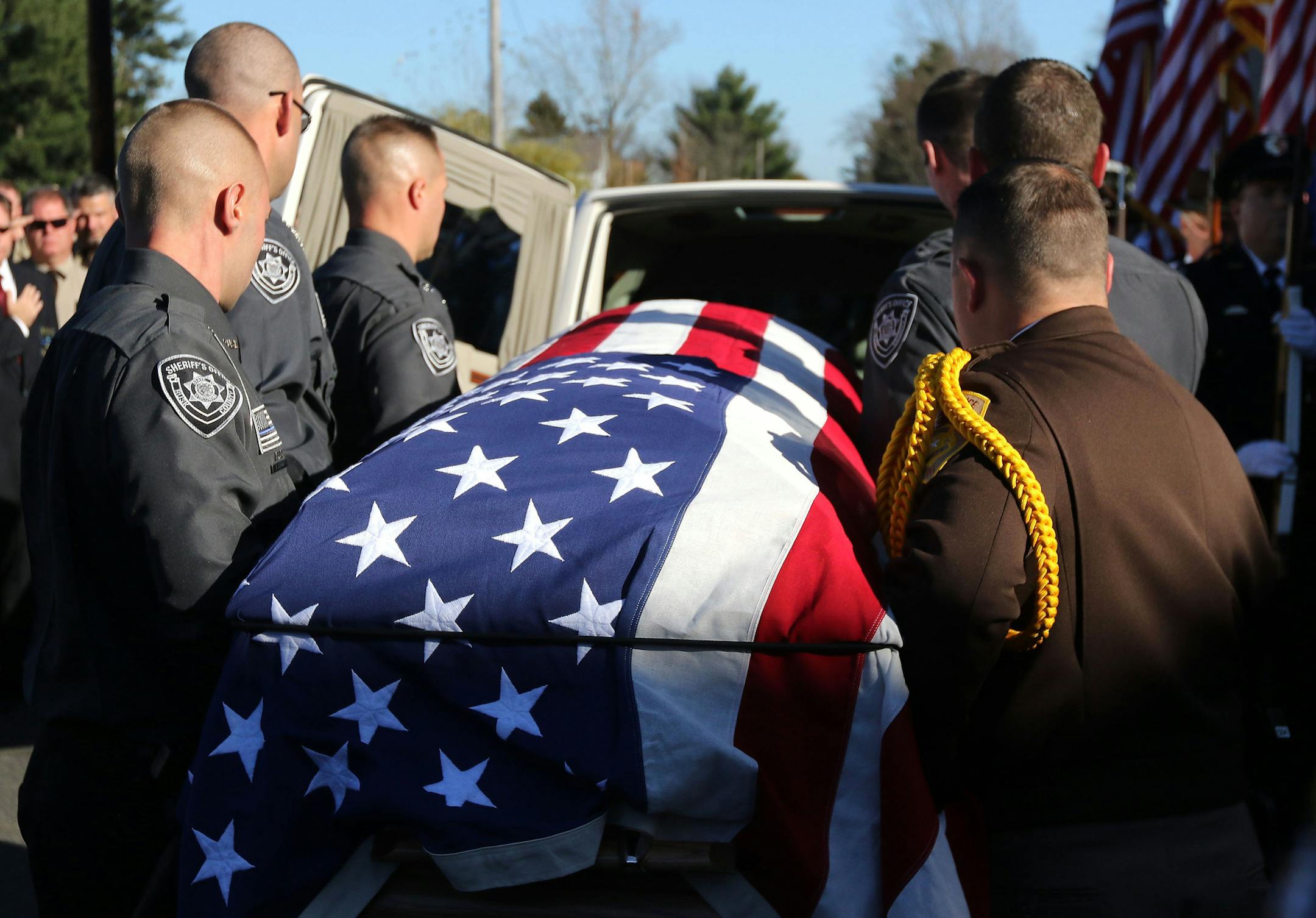 Rusk County deputies place the casket of Rusk County Deputy Sheriff Dan Glaze Jr. into a hearse after a service, Friday, Nov. 4, 2016, at the former Cameron Elementary School in Cameron, Wis. Douglas Nitek is accused of killing Glaze Saturday night, Oct. 29, as the officer investigated a report of a suspicious vehicle in a field several miles from the suspect's residence near Ladysmith, about 130 miles northeast of Minneapolis. (Dan Reiland/The Eau Claire Leader-Telegram via AP) MANDATORY CREDIT