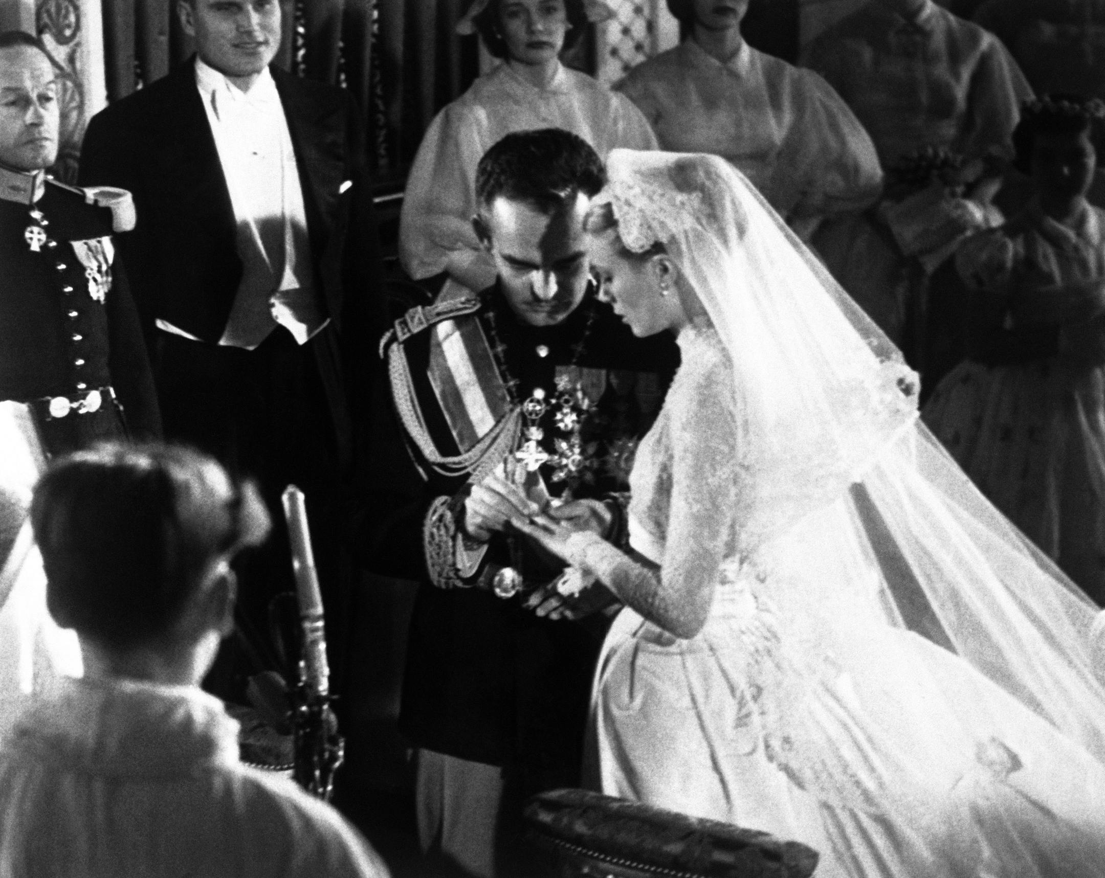 Prince Rainier as he places the ring on Grace Kelly's finger during their wedding ceremony, in Monaco Cathedral