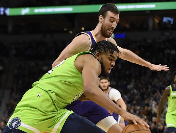 Phoenix Suns' Frank Kaminsky, behind, guards Minnesota Timberwolves' Karl-Anthony Towns during the fourth quarter of an NBA basketball game Saturday, 