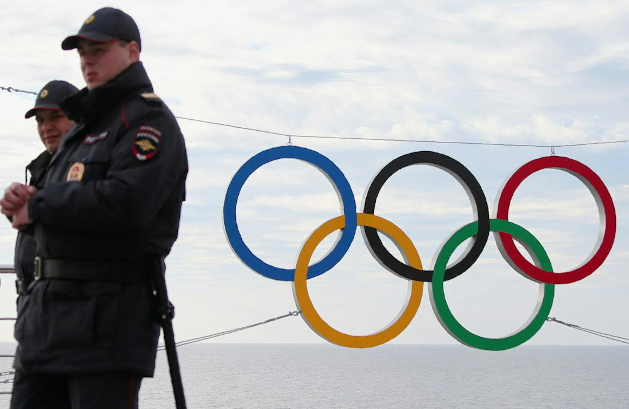 Police officers pass the logo in the Olympic park opened for the 2014 Winter Olympic Games in Sochi.