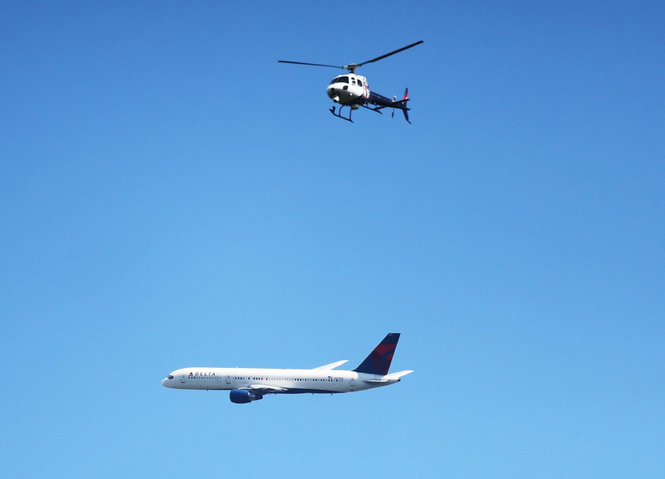 A plane heading for a landing as MSP passes below a news helicopter monitoring the search for an alleged armed robbery suspect near the Mendota Plaza that did not turn up the suspect Saturday, July 29, 2017, in Mendota Heights, MN. The body of a deceased woman was found at a nearby business center and the suspect was believed to have gotten outside the search perimeter.