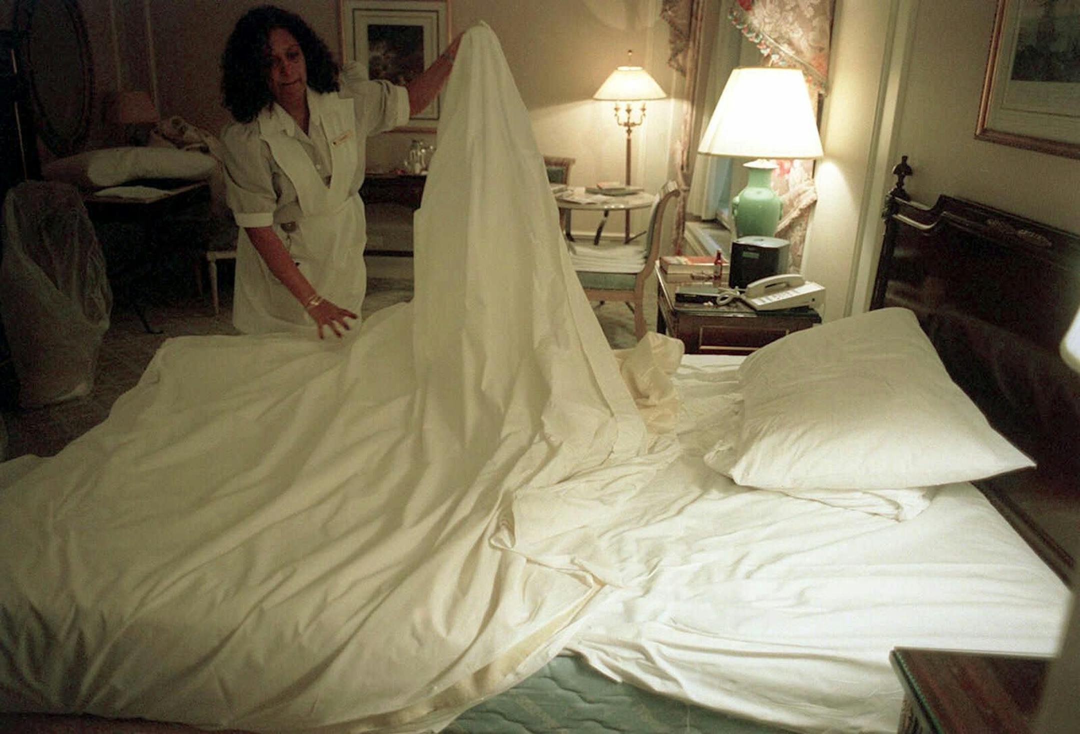 (NYT9) NEW YORK -- Dec. 12, 2000 -- SHEETS-ODYSSEY-1 -- An entire economy revolves around bed sheets. From the hotel that must have a large supply of them to the business executive who sleeps on them to the laundry worker who earns $6.75 an hour cleaning them. Numbers are abstract and ephemeral, slippery like soap bubbles, and they do not tell stories. But a day in the life of a sheet does. Sharon Singh changes sheets at the Stanhope Hotel on Nov. 30, 2000. (Edward Keating/The New York Times) *LITE