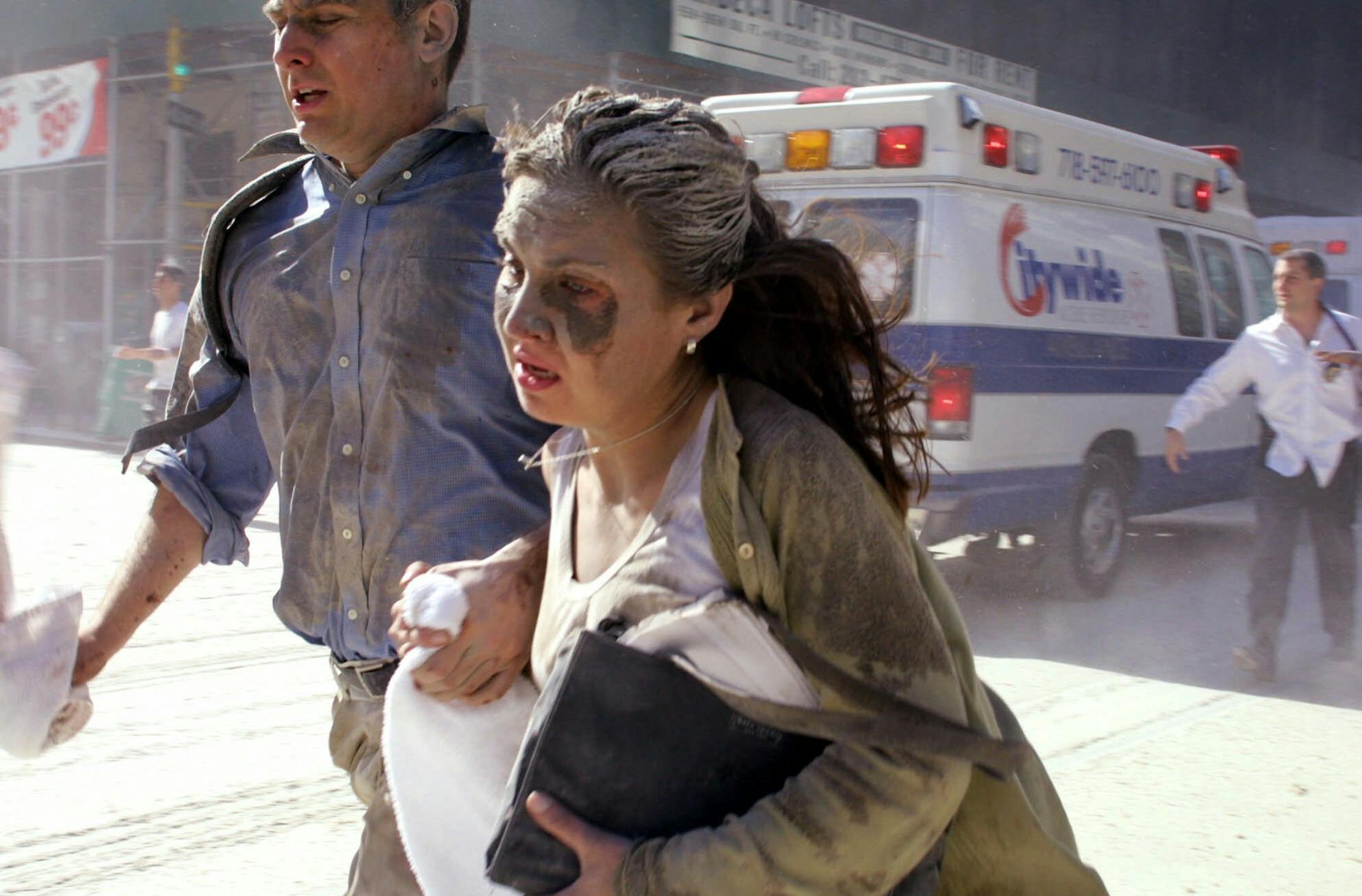 People flee the scene near New York's World Trade Center after terrorists crashed two planes into the towers Tuesday, Sept. 11, 2001. In a horrific sequence of destruction, terrorists hijacked two airliners and crashed them into the World Trade Center in a coordinated series of attacks that brought down the twin 110-story towers. (AP Photo/Diane Bondareff)
