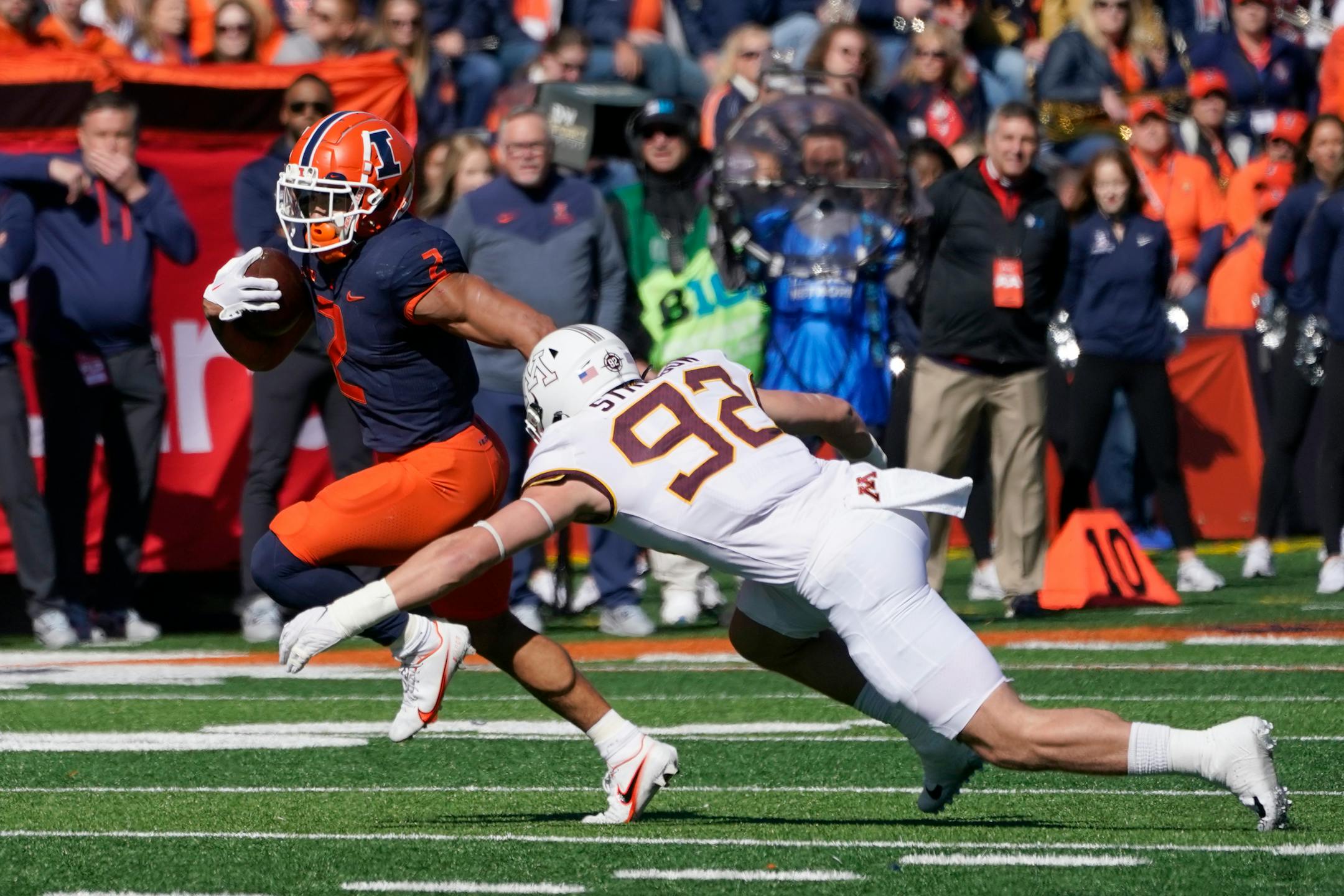 Illinois running back Chase Brown runs away from the outstretched arms of Minnesota defensive lineman Danny Striggow during the first half of an NCAA college football game Saturday, Oct. 15, 2022, in Champaign, Ill. (AP Photo/Charles Rex Arbogast)