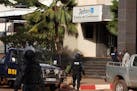 Mali police walk outside one of the entrances to the Radisson Blu hotel's conference center after an attack by gunmen on the hotel in Bamako, Mali, Fr