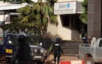 Mali police walk outside one of the entrances to the Radisson Blu hotel's conference center after an attack by gunmen on the hotel in Bamako, Mali, Fr
