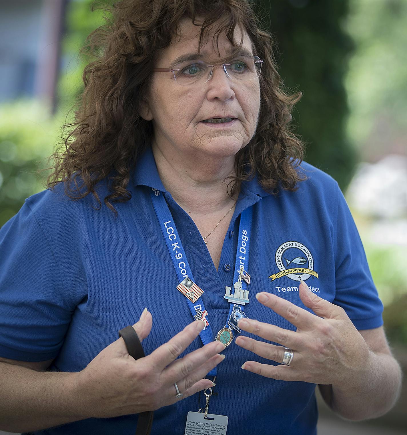 Pam Lienemann of St. Michael's Lutheran Church spoke with a family as she took "Gideon the comfort dog," on a walk, Thursday, July 5, 2018 at Centennial Lake in Edina, MN. ] ELIZABETH FLORES &#xef; liz.flores@startribune.com