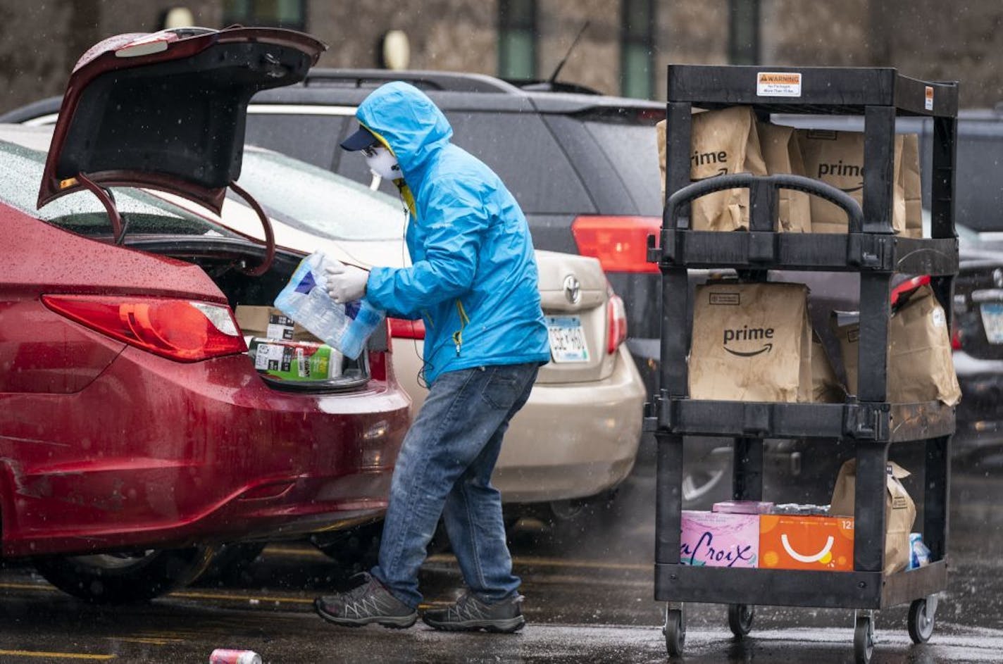 An Amazon Prime Now driver filled up his car with deliveries while wearing a mask and gloves at the Amazon Prime Now hub.