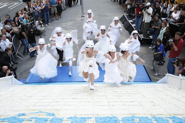 File photo: Brides run up a 10-foot high slice of wedding cake as part of a contest.