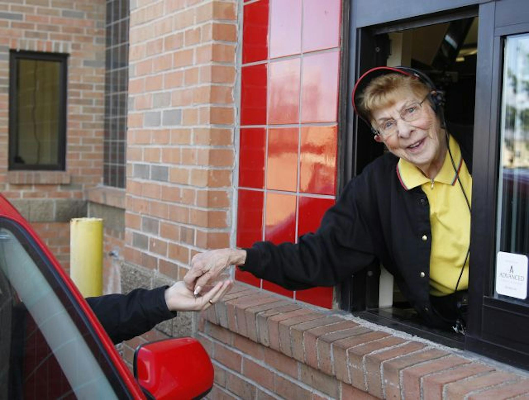 Luverne Penner, 82, handles the drive-through window at the Maple Grove Wendy's.