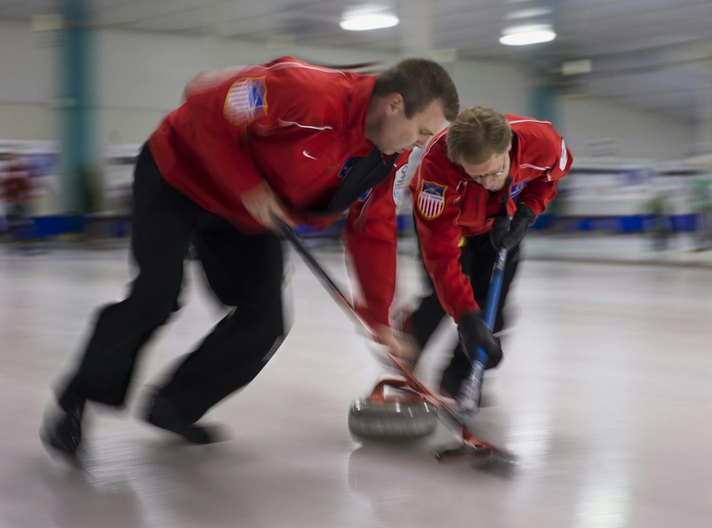 Tim Solin and Ken Olson, both local residents, were a blur of activity as their stone glides across the ice in senior men's curling competition at the St.Paul Curling Club Sunday night.