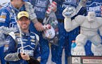 Jimmie Johnson sprayed sparking wine as he celebrated in Victory Lane after he won the NASCAR Sprint Cup series auto race at Dover International Speed