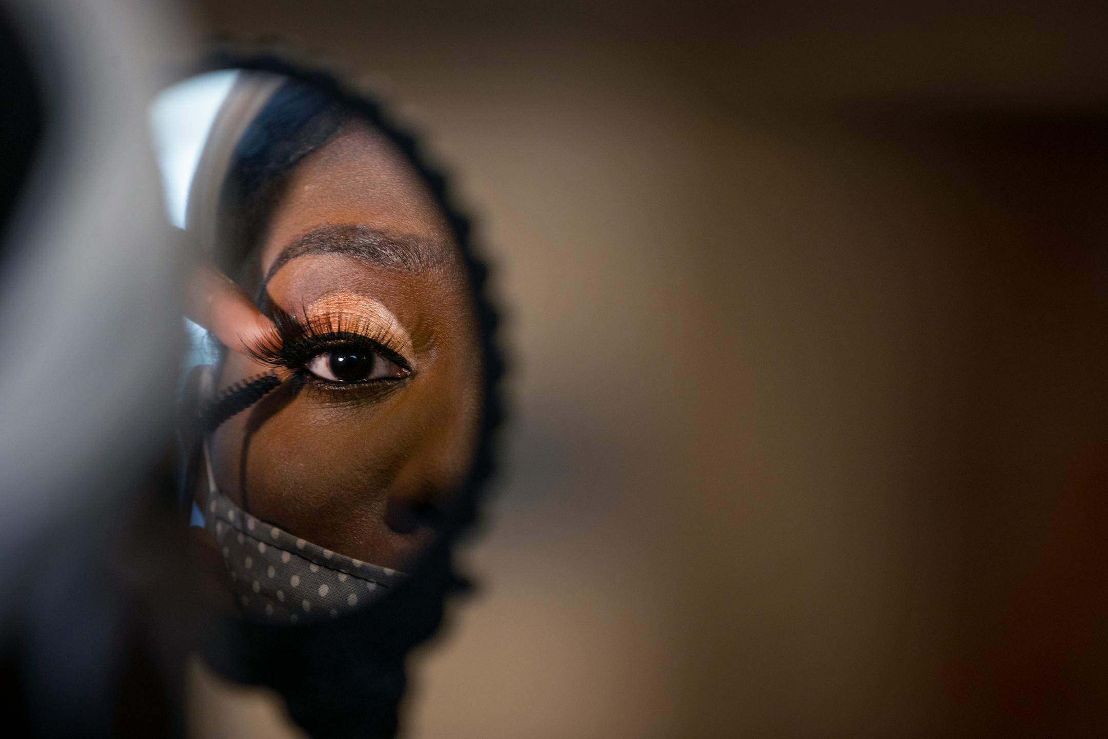 Dynasty Born Asia watched through a mirror as makeup artist Morayo Allibalogun worked on her face during the Kings and Queens Day event at YouthLink, Wednesday, February 24, 2021 in Minneapolis.