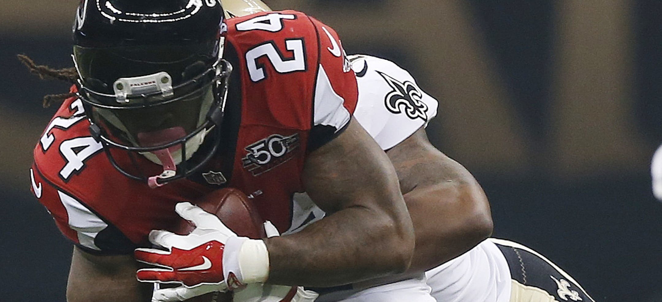 Atlanta Falcons running back Devonta Freeman (24) is hit by New Orleans Saints middle linebacker Stephone Anthony (50) during the first half of an NFL football game, Thursday, Oct. 15, 2015, in New Orleans. (AP Photo/Gerald Herbert)