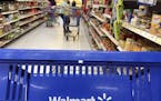 FILE- In this June 5, 2017, file photo, customers shop for food at Walmart in Salem, N.H. Walmart reports financial results Tuesday, Feb. 20, 2018. (A