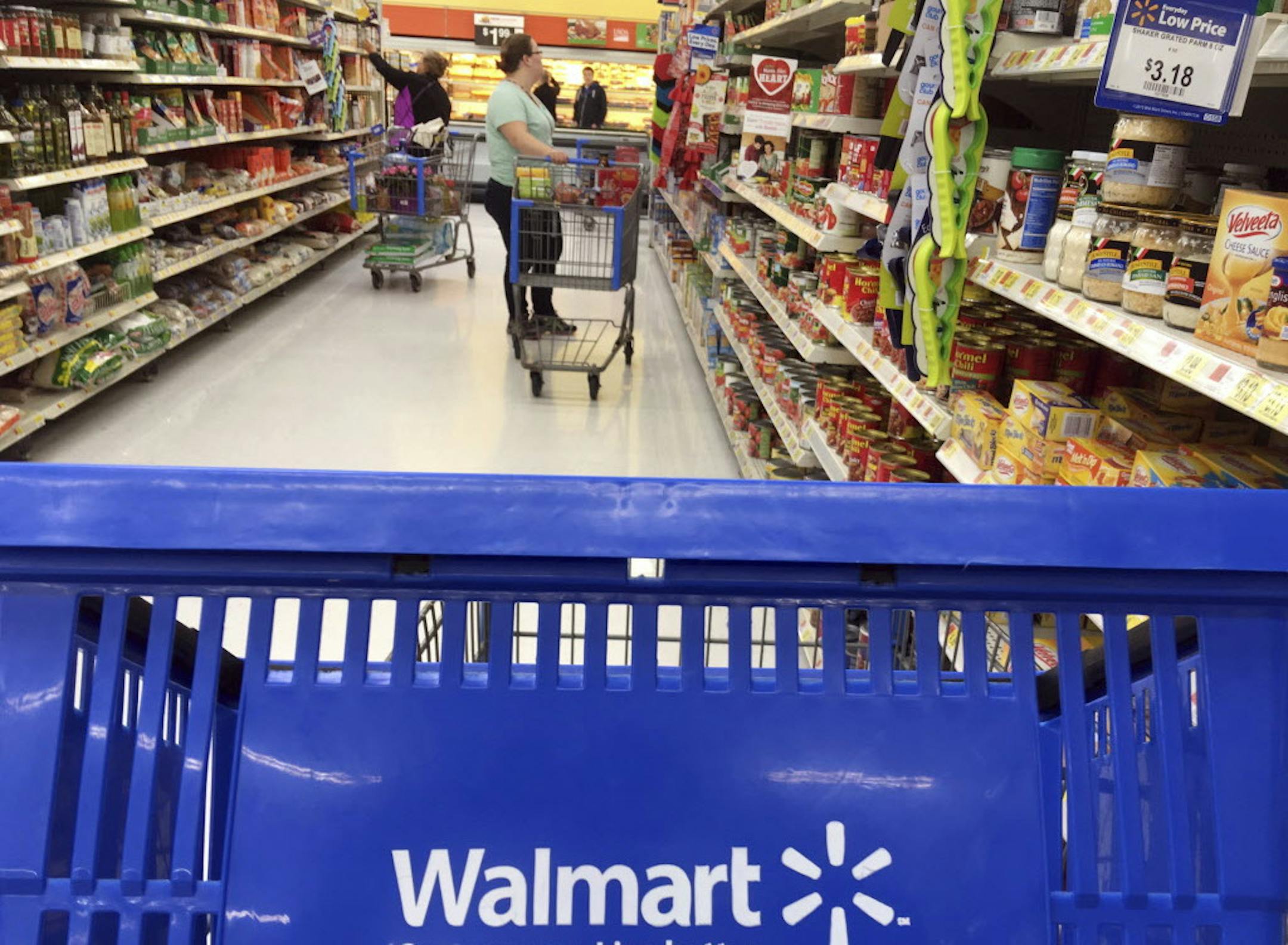 FILE- In this June 5, 2017, file photo, customers shop for food at Walmart in Salem, N.H. Walmart reports financial results Tuesday, Feb. 20, 2018. (AP Photo/Elise Amendola, File)