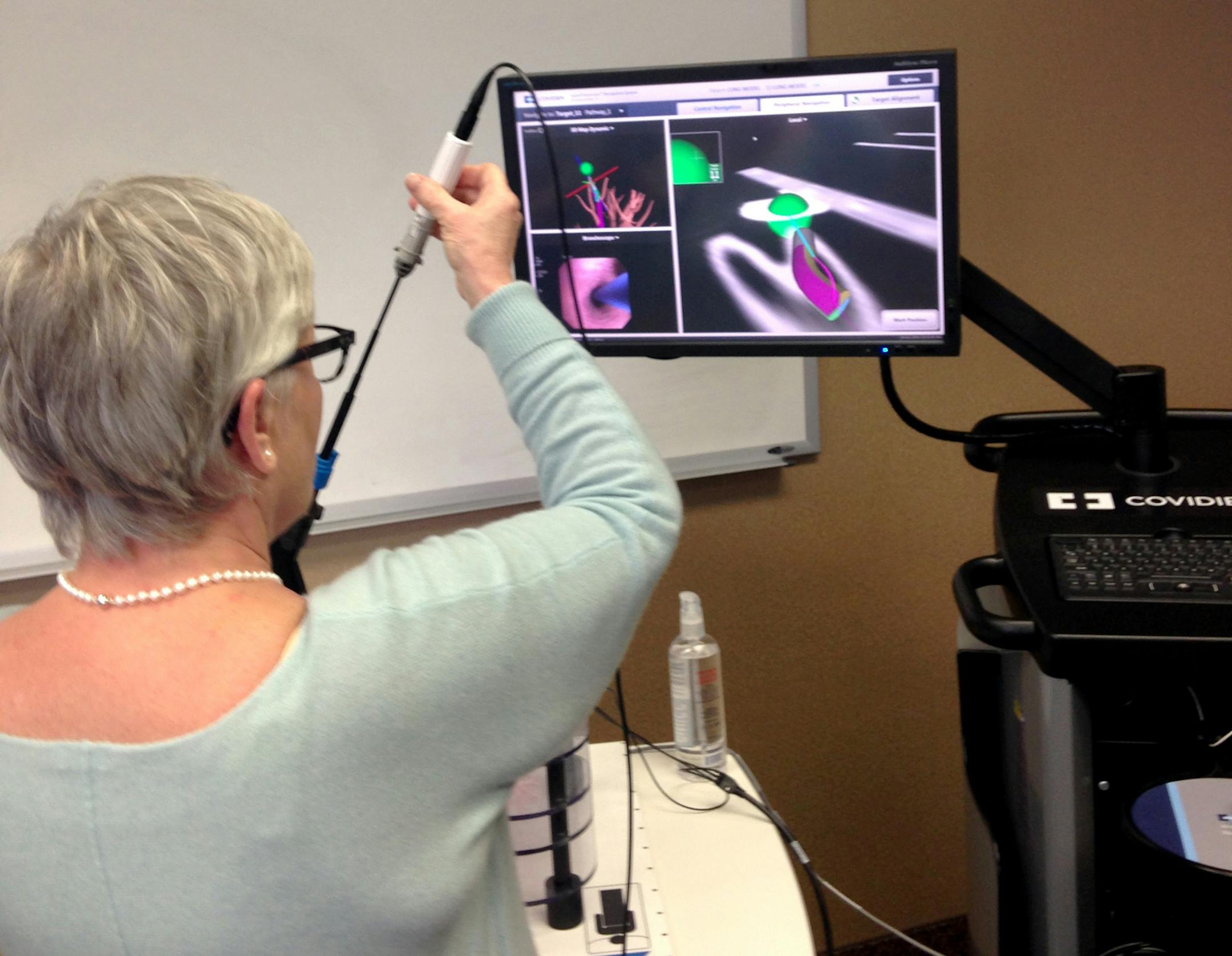 Super D vice president Michele Bazinet-Bossert demonstrates a device made by a Plymouth company called SuperDimension. The device is used to guide a probe deep inside the lung to take a tissue sample for cancer biopsy. The virtual bronchroscopy is done before the procedure to map a path for the lung probe.