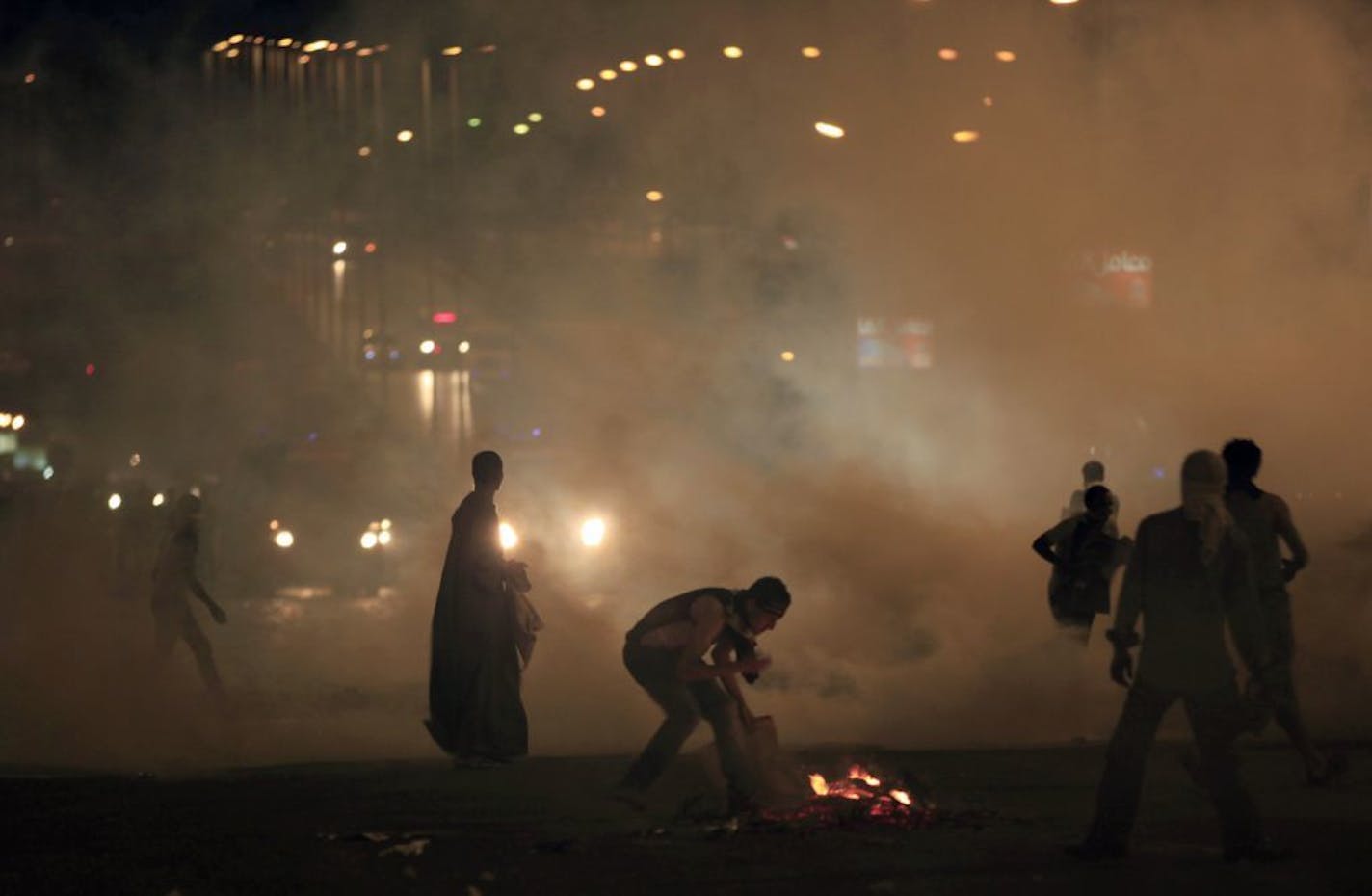 Supporters of Egypt's ousted President Mohammed Morsi throw stones at riot police during clashes at Nasr City, where protesters have installed their camp and hold their daily rally, in Cairo, Egypt, Friday, July 26, 2013. Prosecutors opened an investigation of ousted President Mohammed Morsi on charges including murder and conspiracy with the Palestinian militant group Hamas, fueling tensions amid a showdown in the streets between tens of thousands of backers of the military and supporters calli