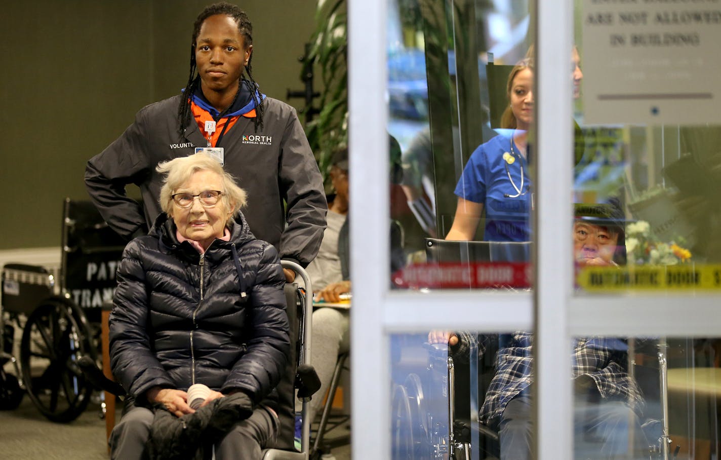 Osseo High School senior Christopher Allen volunteers at North Memorial Medical Center. Here, he prepared to wheel discharged patient Mary Lou Wensman to a waiting vehicle.