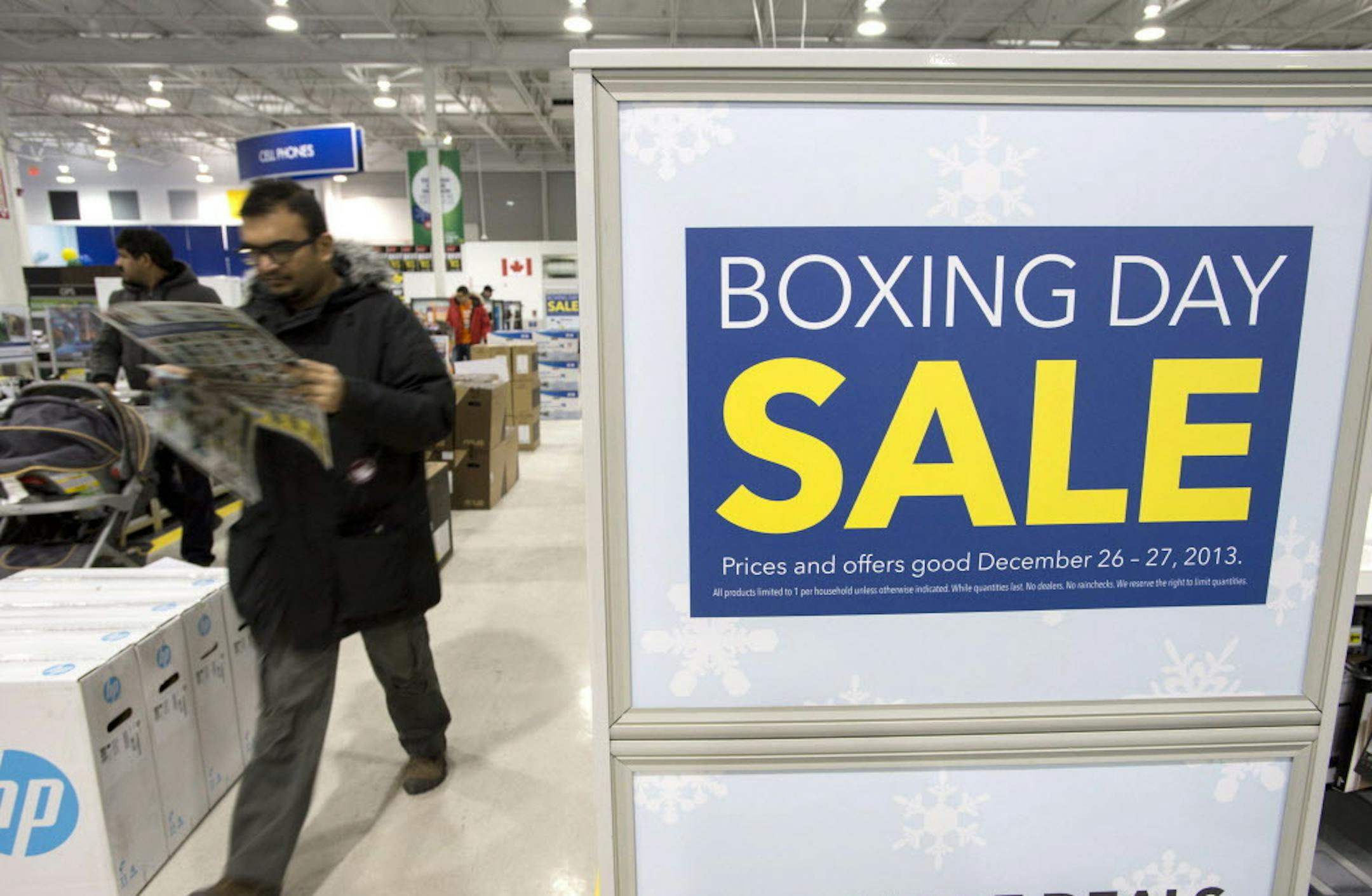 A shopper reads a flyer on Boxing Day at Best Buy in Ottawa on Thursday, Dec. 26, 2013. Boxing Day, observed in Canada, the United Kingdom, and other Commonwealth nations on the day after Christmas, is primarily known as a shopping holiday, much like Black Friday in the United States. (AP Photo/The Canadian Press, Justin Tang)