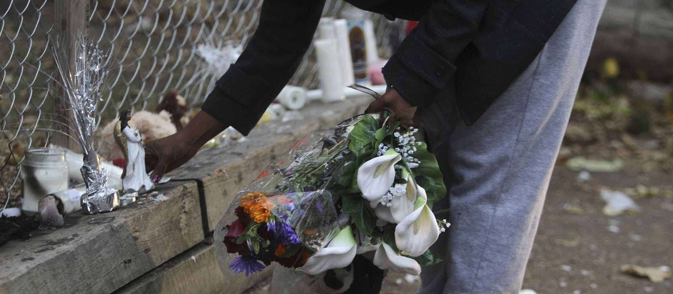 A memorial site set up near where Naressa Turner was killed appears to have been vandalized overnight, shortly after a vigil for Turner was held in the alley behind 970 Reaney Ave. in St. Paul, MN. and was photographed Tuesday, Oct. 16, 2012. Here, a friend who wanted to be identified only as Sheena came by the site and cleaned up broken glass and put flowers and stuffed animals that had been thrown on the ground back along the fence.] (DAVID JOLES/STARTRIBUNE) djoles@startribune.com man was sho