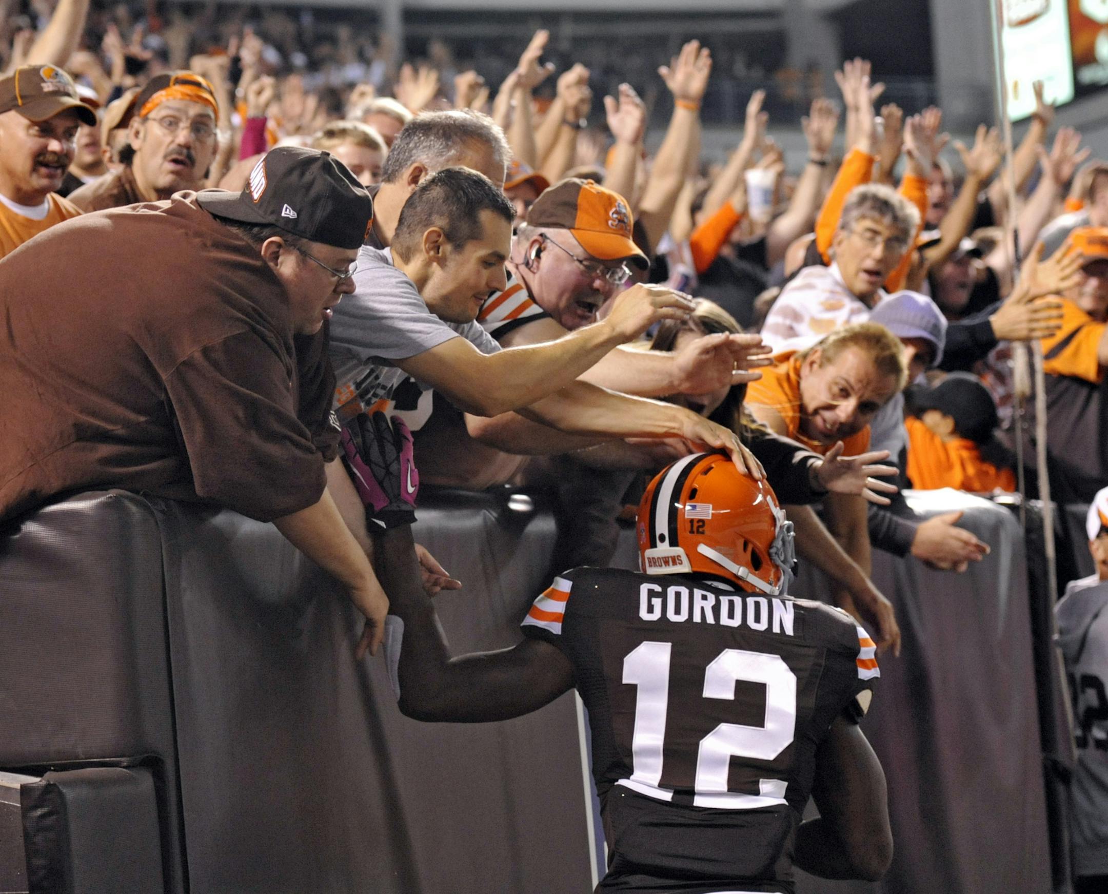 Fans congratulate Cleveland Browns wide receiver Josh Gordon (12) after his 37-yard touchdown catch against the Buffalo Bills in the third quarter of an NFL football game Thursday, Oct. 3, 2013, in Cleveland. (AP Photo/David Richard)