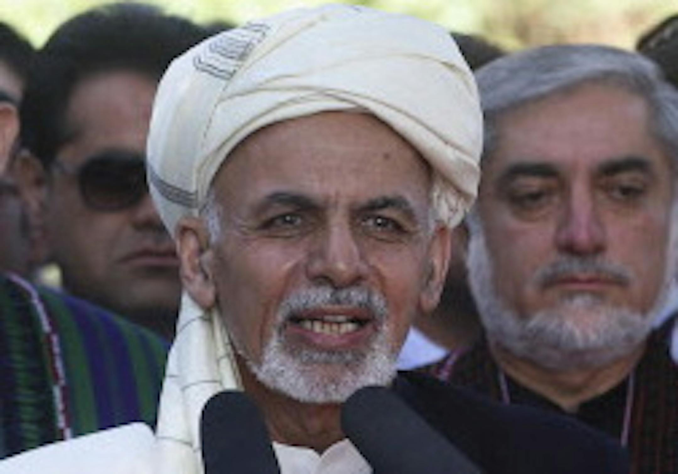Afghanistan's President Ashraf Ghani Ahmadzai, center, speaks during the Eid al-Adha (Eid-e Qurban in local language) prayer ceremony at the presidential palace as former President Hamid Karzai, left, listens in Kabul, Afghanistan, Saturday, Oct. 4, 2014. Ghani Ahmadzai's inauguration this week marked the start of a new era for his country, with a national unity government poised to confront a resilient Taliban insurgency. Abdullah Abdullah, center right, was appointed the country's new chief ex