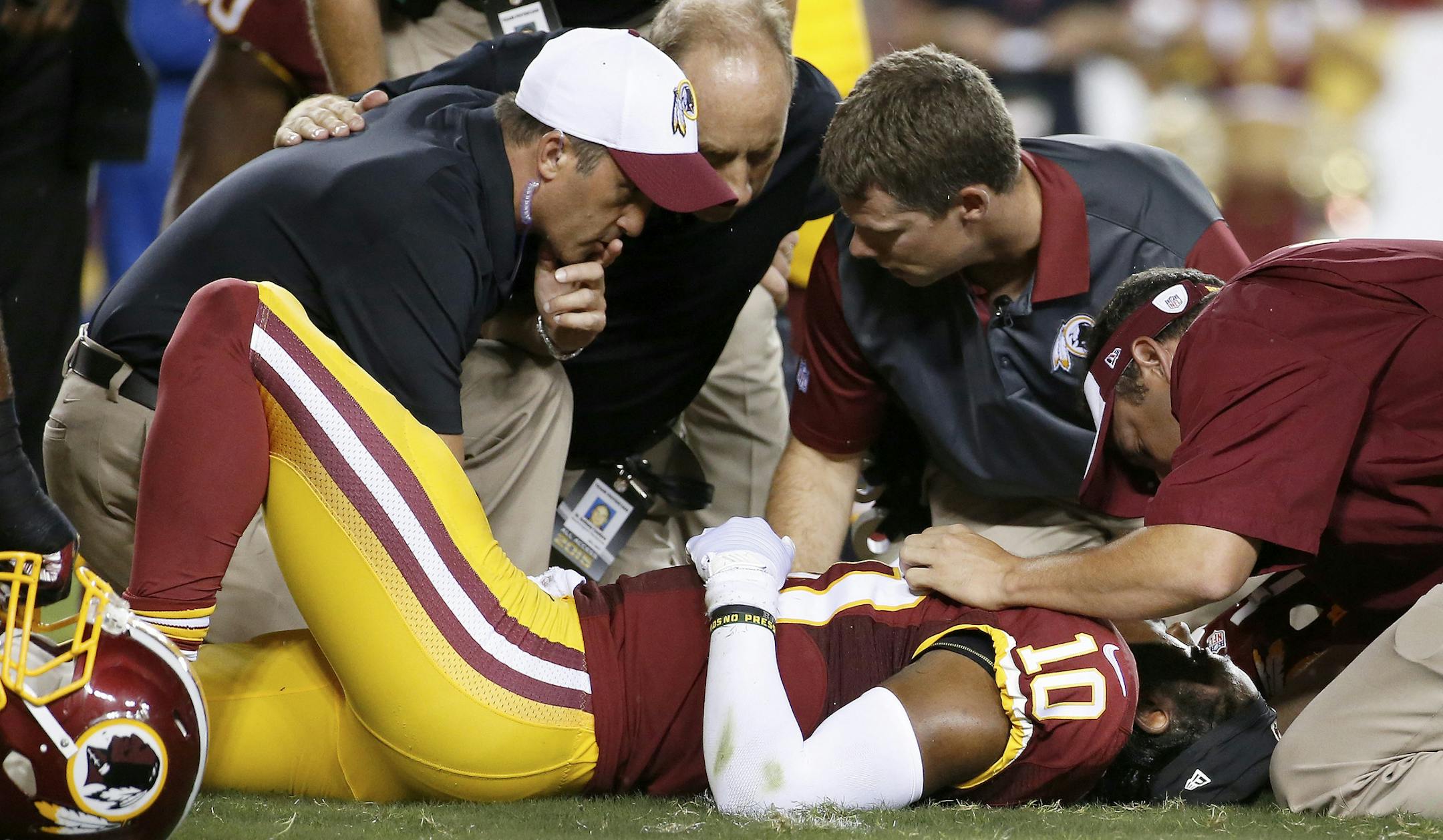Washington Redskins quarterback Robert Griffin III (10) is examined after an injury during the first half of an NFL preseason football game against the Detroit Lions, Thursday, Aug. 20, 2015, in Landover, Md. (AP Photo/Alex Brandon)