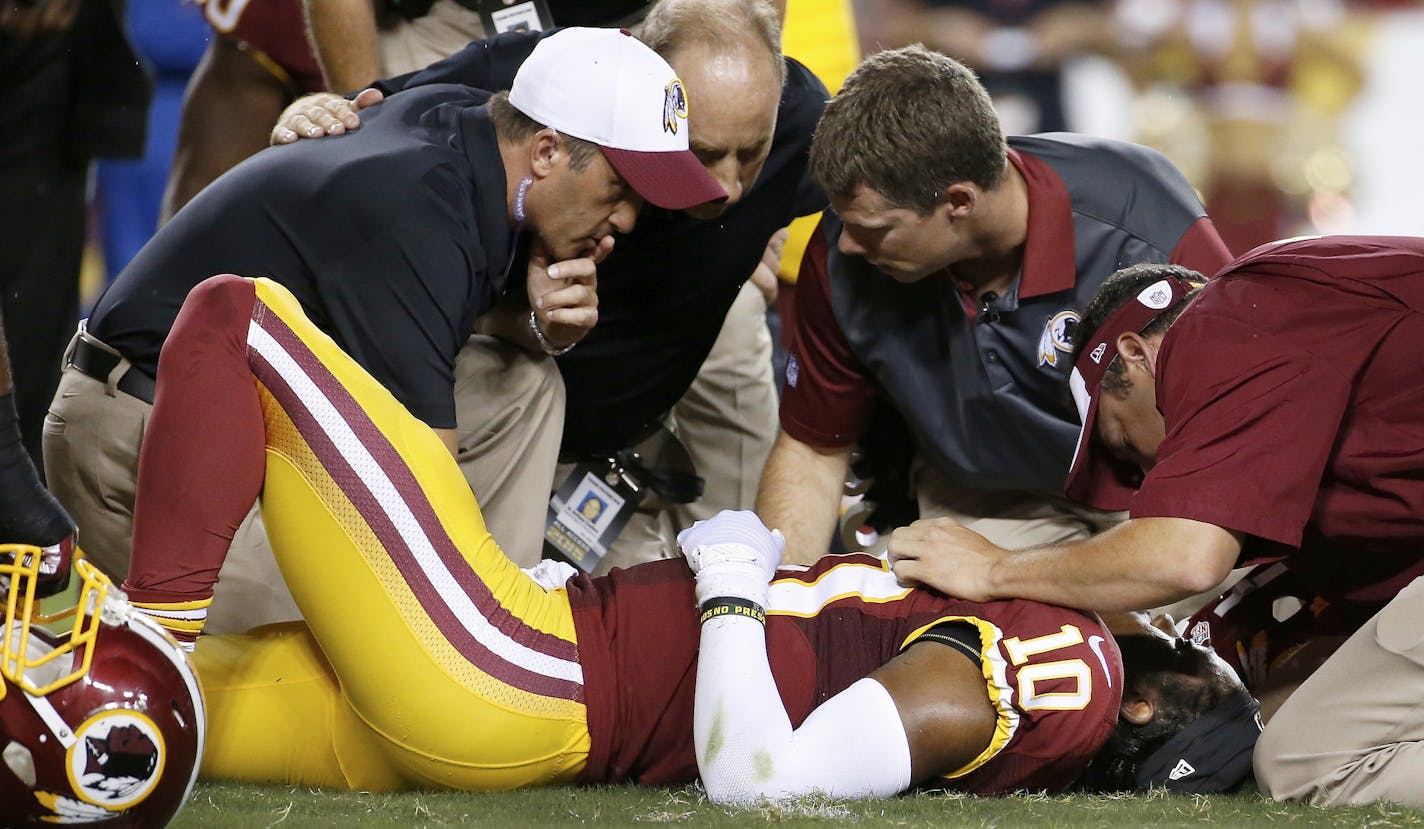 Washington Redskins quarterback Robert Griffin III (10) is examined after an injury during the first half of an NFL preseason football game against the Detroit Lions, Thursday, Aug. 20, 2015, in Landover, Md. (AP Photo/Alex Brandon)