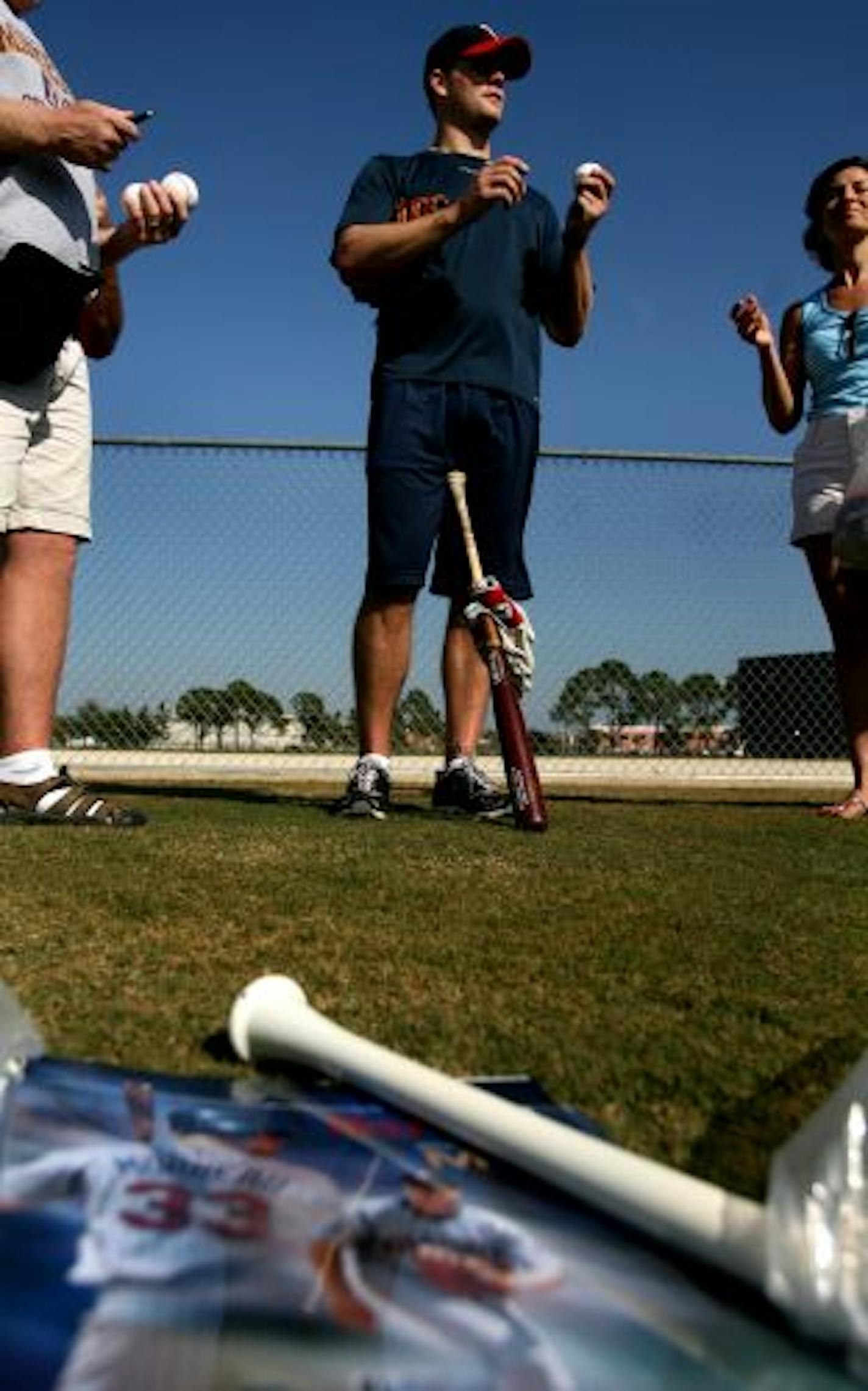 Twins first baseman Justin Morneau autographed a baseball for a fan after Tuesday morning workout at Fort Myers.