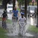 Cornell Smith, 11, pedaled fast through flooding along Dunwoody Boulevard on Tuesday on the way to a Twins game at Target Field. Smith and his brother
