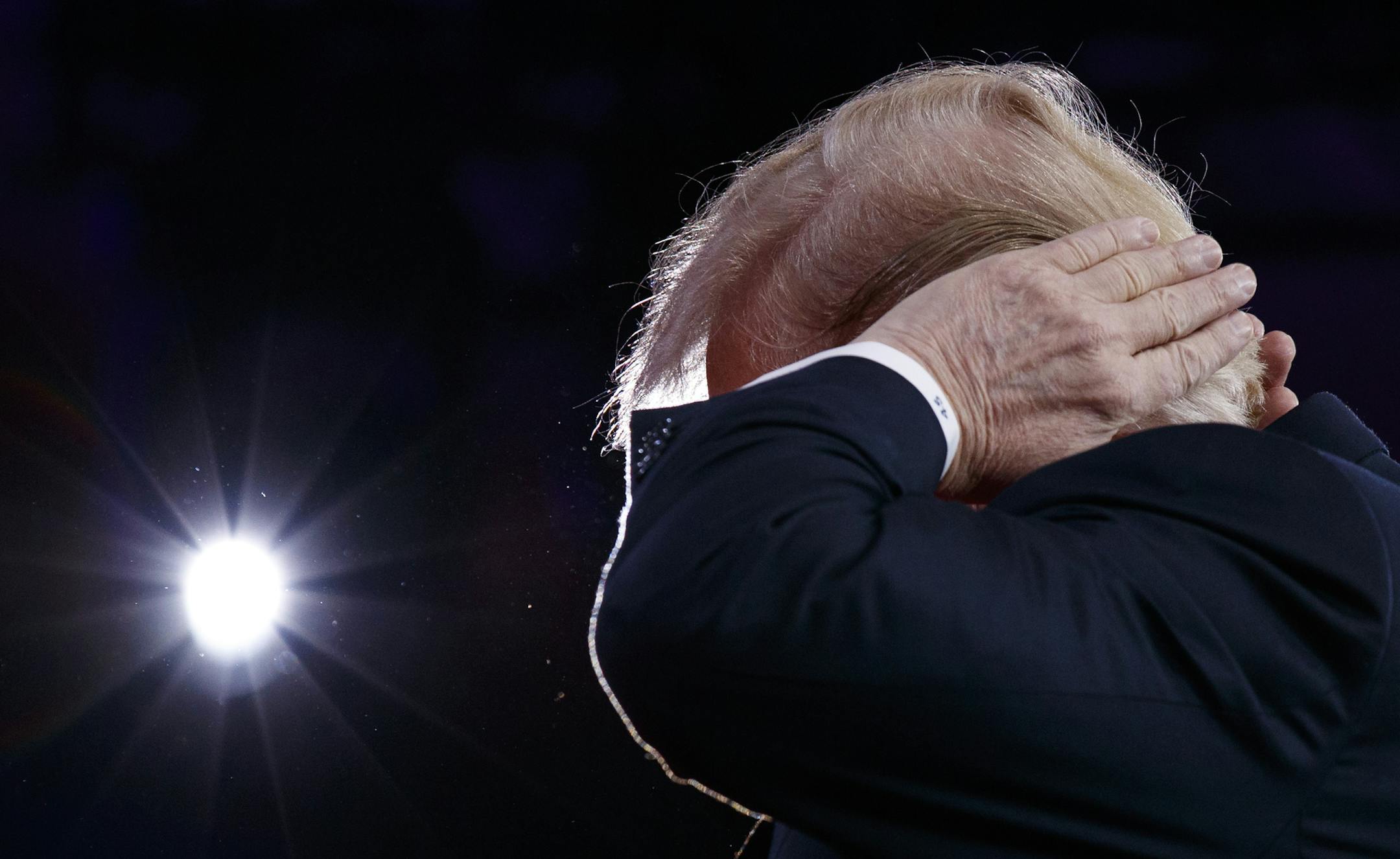 President Donald Trump gestures as he makes a joke about his hair during remarks to the Conservative Political Action Conference, Friday, Feb. 23, 2018, in Oxon Hill, Md. (AP Photo/Evan Vucci) ORG XMIT: DCEV118