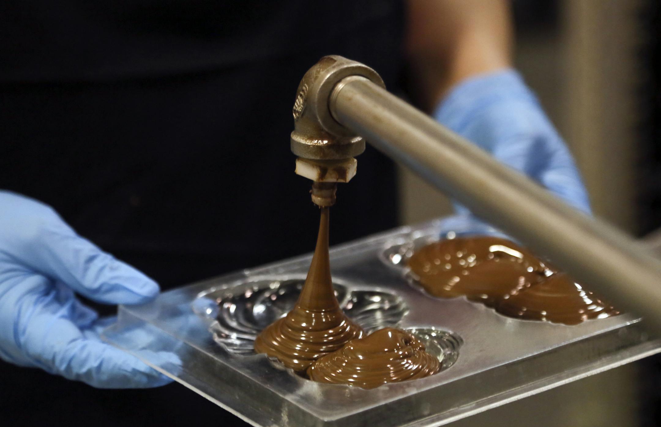 Candy maker Malysorphorn Lean molds liquid milk chocolate into solid milk chocolate Santa Clause's Tuesday, Nov. 19 at Abdallah's Candies in Burnsville, MN.](DAVID JOLES/STARTRIBUNE) djoles@startribune.comThe production lines are humming at Abdallah's Candies, the 100-year-old maker of chocolates, caramels and toffees that's been a mainstay in Burnsville since the 1960s. Christmas accounts for about 35 percent of its business. The Burnsville facility has a small shop but most of its devoted to p