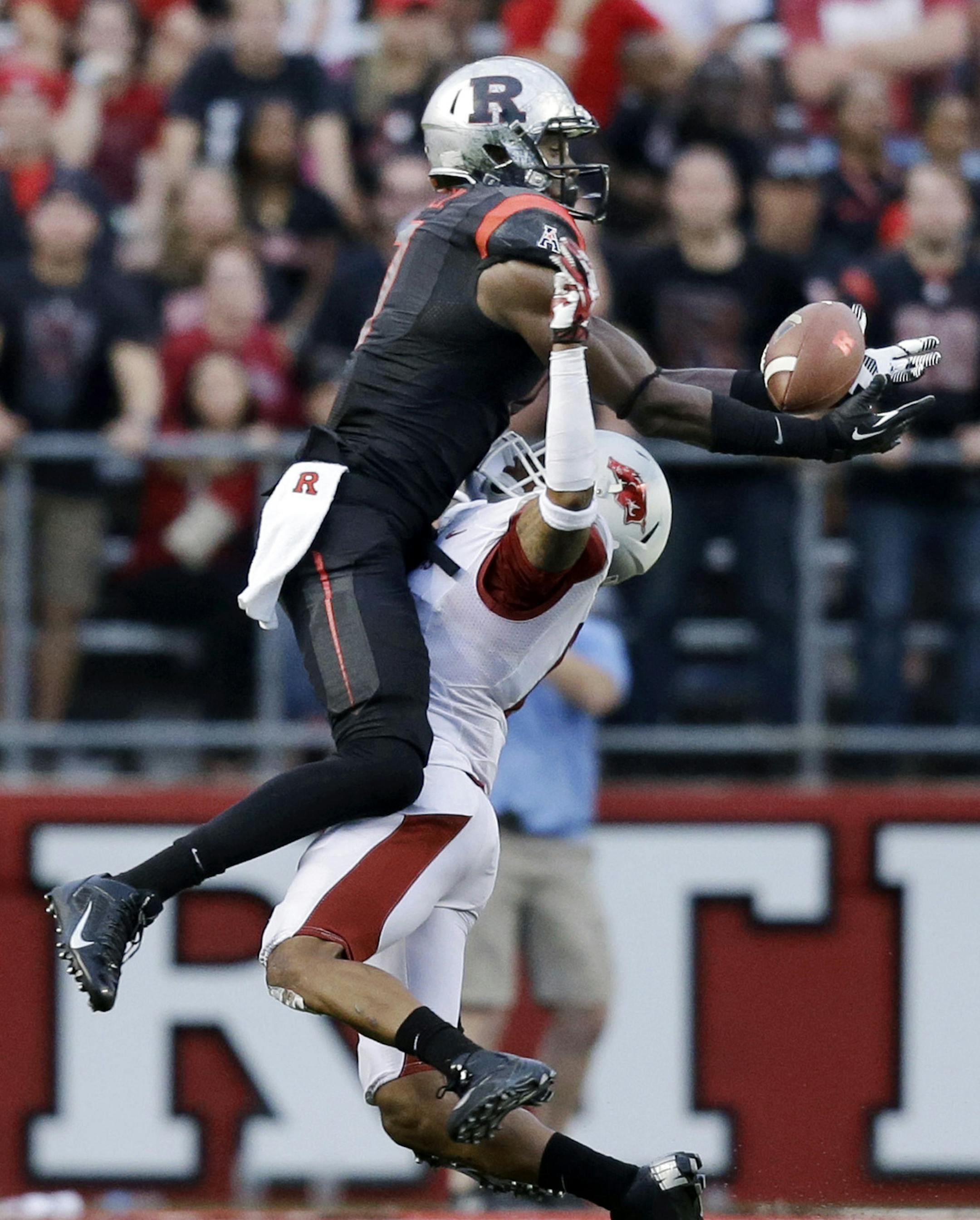 Rutgers wide receiver Brandon Coleman, left, catches a pass late in the fourth quarter over Arkansas corner back Tevin Mitchel during an NCAA college football game in Piscataway, N.J., Saturday, Sept. 21, 2013. Rutgers won 28-24. (AP Photo/Mel Evans)