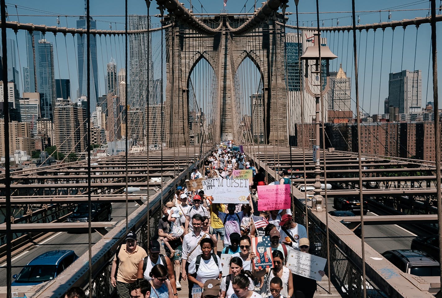 Protesters hold signs and yell during a demonstration march on the Brooklyn Bridge in New York, June 30, 2018. Demonstrators and activists gathered en masse at Foley Square to protest the Trump administration&#xed;s &#xec;zero tolerance&#xee; immigration policy. (Christopher Lee/The New York Times)