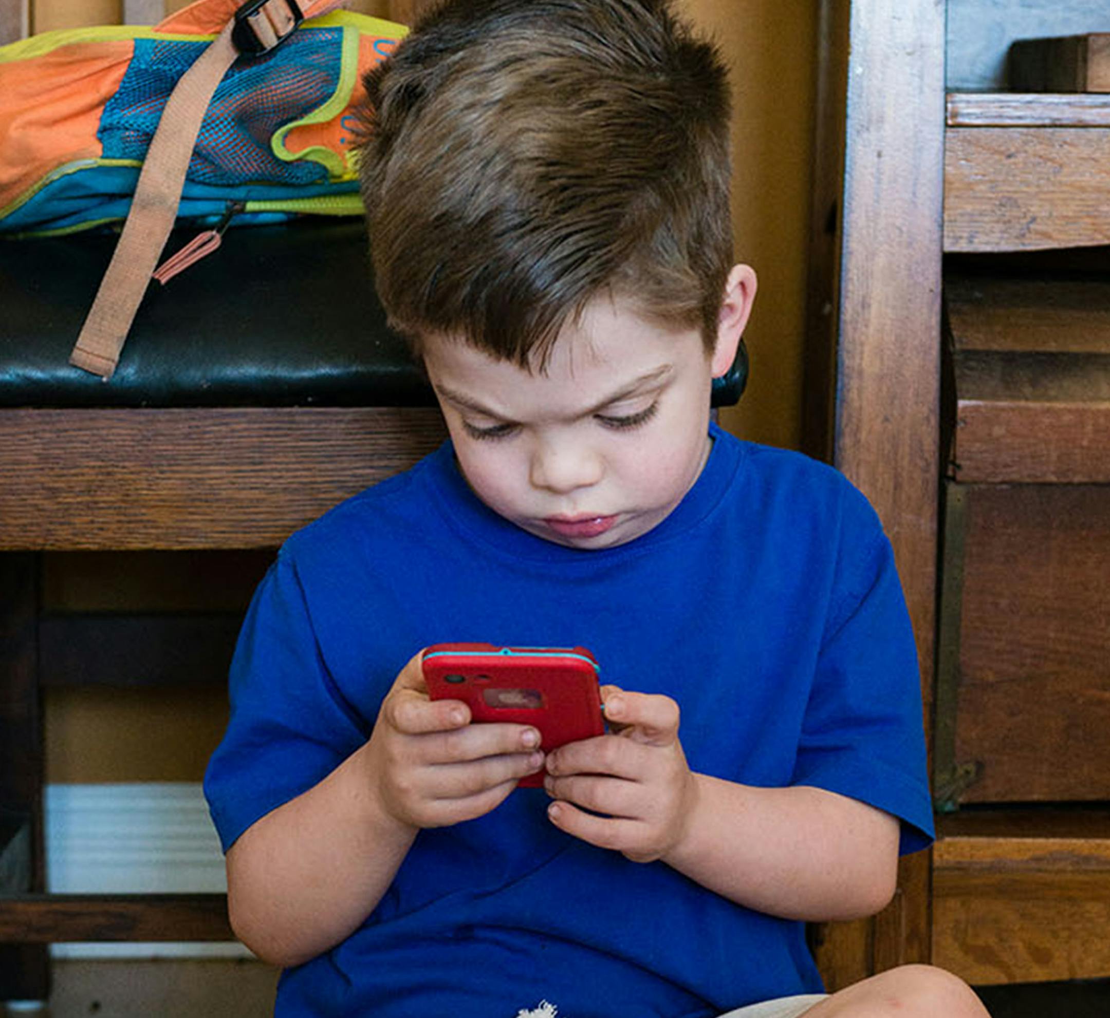 Kevin Tuite was born with severe hemophilia with a complication known as an inhibitor - an antibody that makes his regular blood factor infusions less effective. He plays a game on the phone while he waits for his blood factor infusion on Feb. 23, 2018. (Heidi de Marco/KHN)