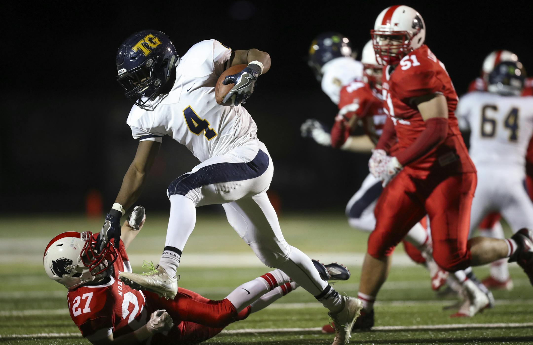 Totino-Grace's Gayflor Flomo pushed down Lakeville North's Spencer Fossey on a second quarter carry. ] JEFF WHEELER ï jeff.wheeler@startribune.com Lakeville North and Totino-Grace high schools met in a Class 6A football quarterfinal playoff game at Kuhlman Field in Edina Thursday night, November 10, 2016.