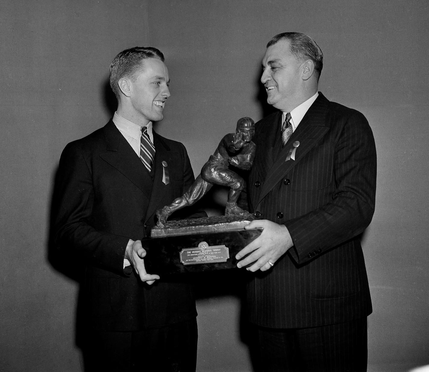 Captain of the University of Minnesota Bruce Smith, left, receives the Heisman trophy from Joseph R. Taylor of the Downtown Athletic Club in New York, Dec. 9, 1941. (AP Photo) ORG XMIT: APHS447147