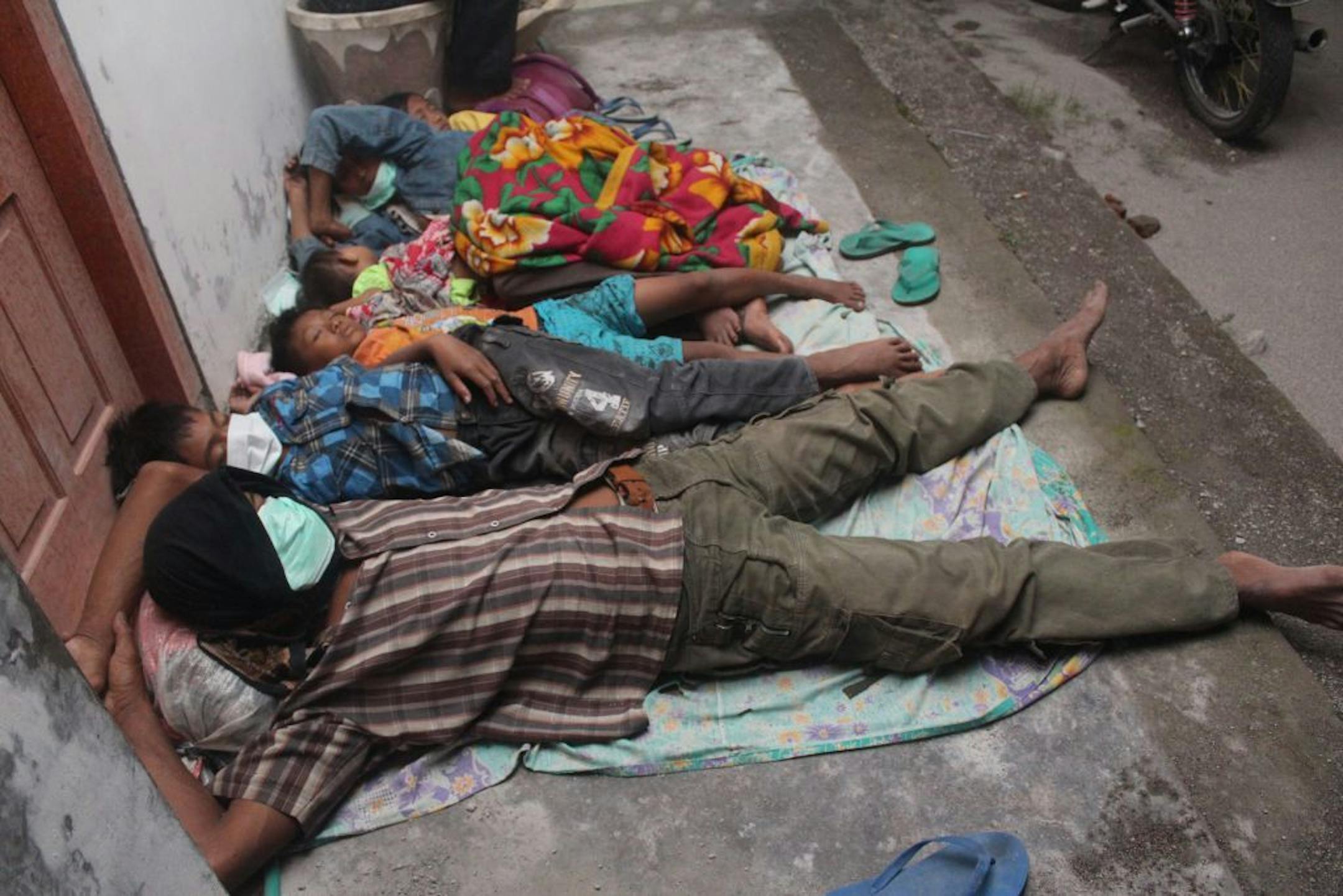 Villagers sleep at a temporary shelter after they were evacuated from their homes on the slopes of Mount Kelud in Kediri, East Java, Indonesia, Friday, Feb. 14, 2014.