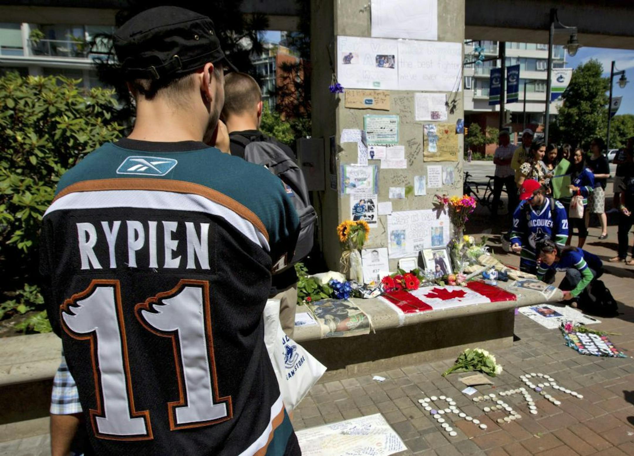 Tyler Stychyshyn wears a Manitoba Moose jersey as he pauses at a makeshift memorial for former Vancouver Canucks hockey player Rick Rypien as fans gather to honor Rypien outside Rogers Arena in Vancouver, British Columbia, on Wednesday, Aug. 17, 2011. Rypien, who signed a one-year deal with the Winnipeg Jets in July, was found dead at his Alberta, Canada, home on Monday.