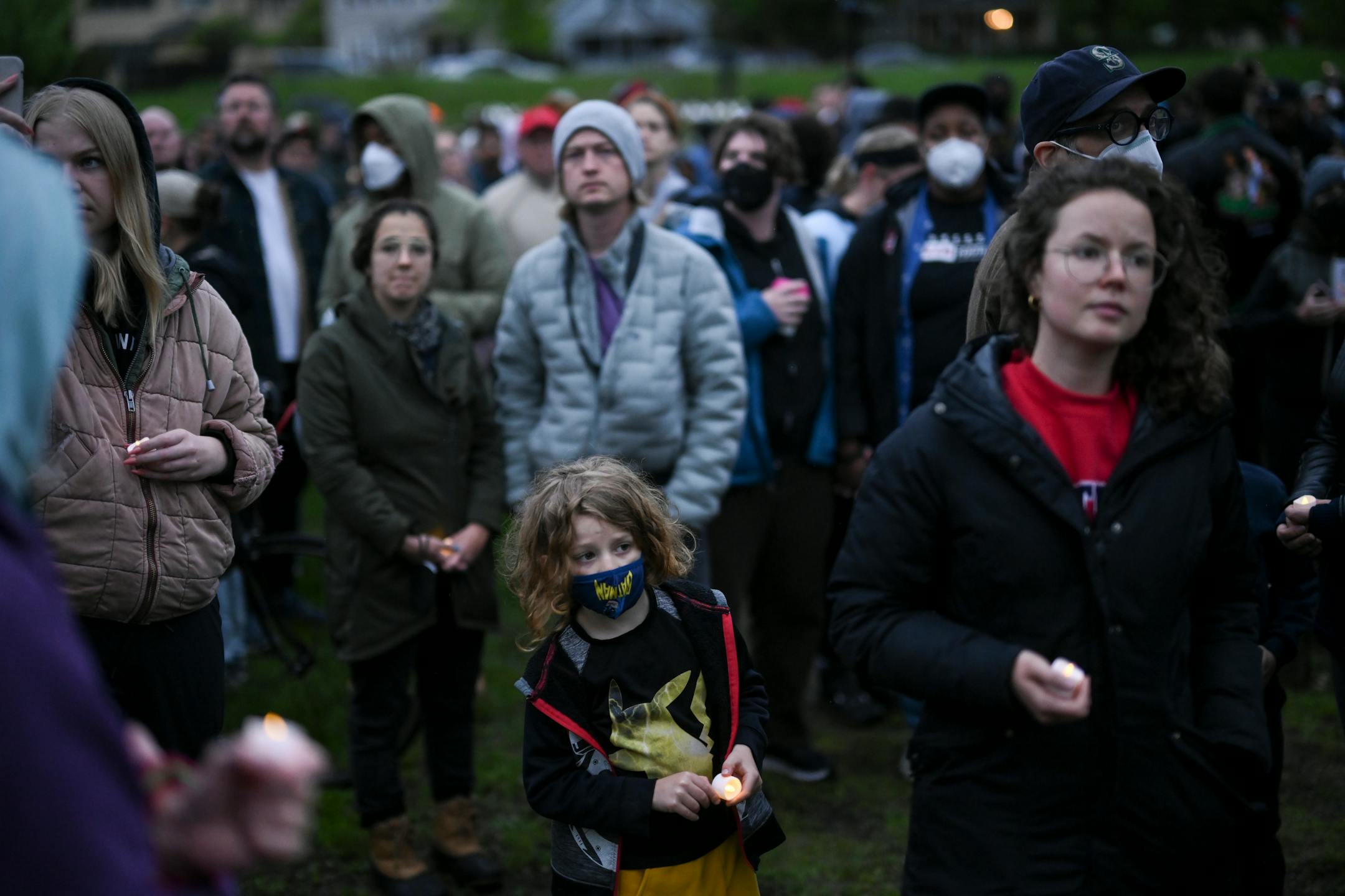 Community members hold candles during a vigil at the "Say Their Names" cemetery.