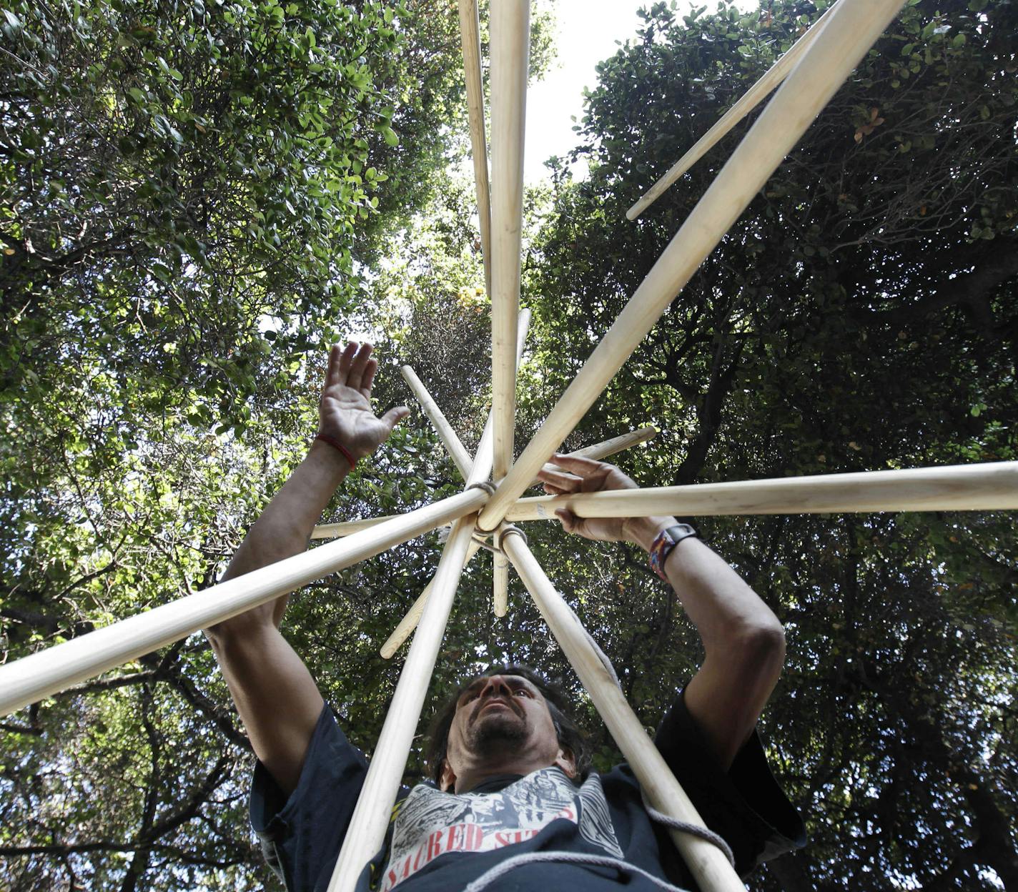 Occupy Oakland demonstrator Zachary Runningwolf builds a ceremonial Native American tepee outside of Oakland City Hall in Oakland, Calif., Tuesday, Nov. 29, 2011. Occupy Oakland activists plan to retake the plaza in front of City Hall although they don't plan to set up tents this time. The group says it will instead hold a 24-hour-a-day, seven-day-a week vigil in Frank Ogawa Plaza. (AP Photo/Paul Sakuma) ORG XMIT: CAPS113