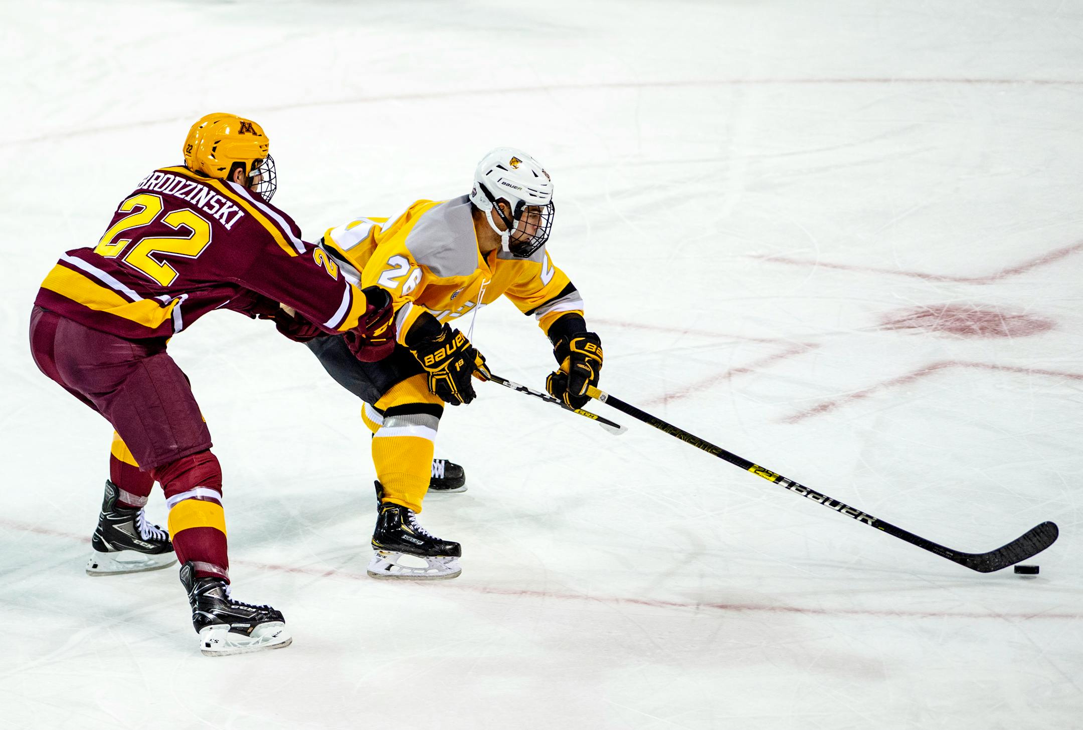 Colorado College defenseman Brady Smith, right, fights to maintain control of the puck as Gophers forward Bryce Brodzinski defends during the first period Friday night.