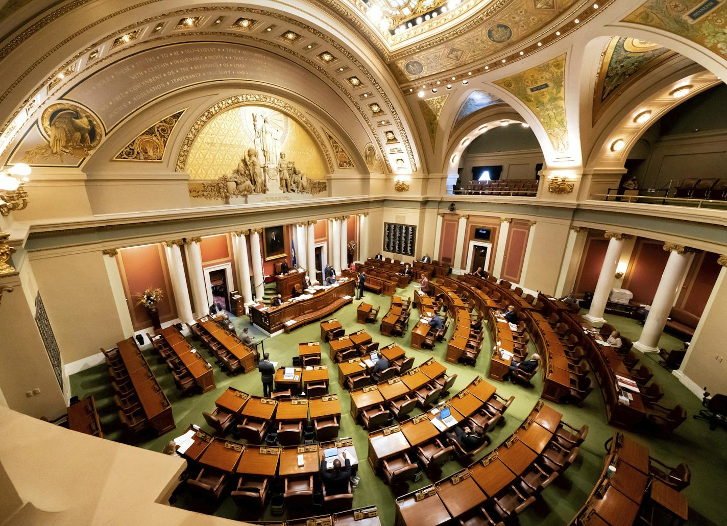 The Minnesota legislature meets in special session Monday, July 13, 2020, in St. Paul, Minn. Social distancing requires a small number of legislators in the House chamber. The rest participate remotely. (Glen Stubbe/Star Tribune via AP)