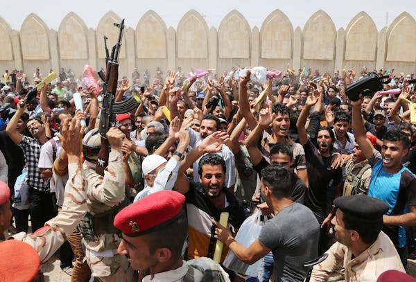 Iraqi men chant slogans against the al-Qaida breakaway group Islamic State of Iraq and the Levant (ISIL), outside of the main army recruiting center t