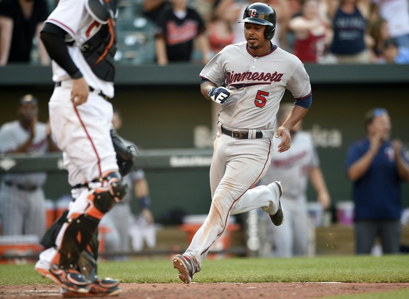 Minnesota Twins' Eduardo Escobar runs home to score during the 12th inning of a baseball game as Baltimore Orioles catcher Caleb Joseph waits, Sunday, Aug. 23, 2015, in Baltimore. The Twins' Shane Robinson reached first on a fielding error by Orioles' Jimmy Paredes on the play. The Twins won 4-3 in 12 innings. (AP Photo/Nick Wass)