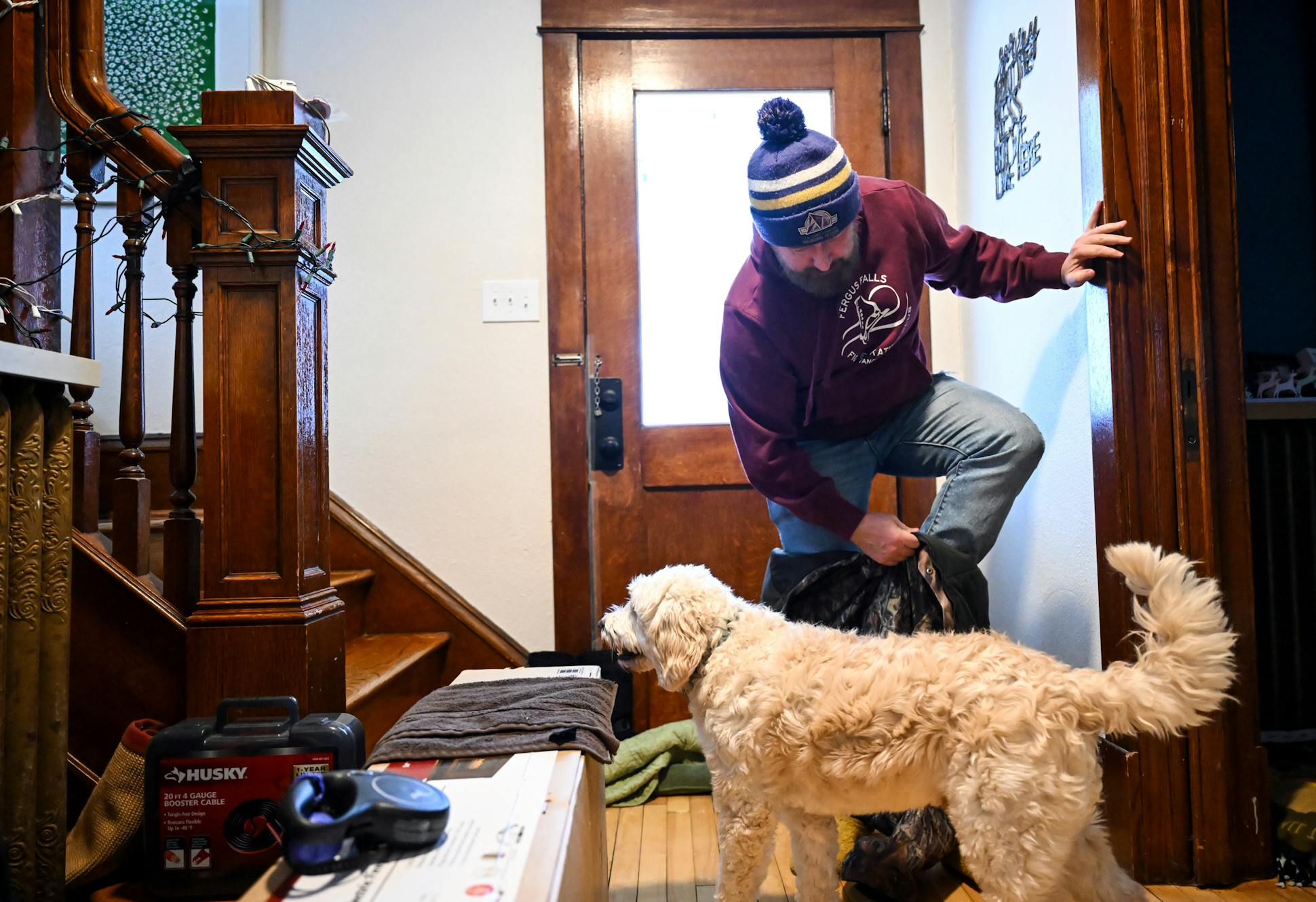 Chad Daniels put on his snow bib while preparing to take his three-year old goldendoodle, Po, to play at a nearby school.
