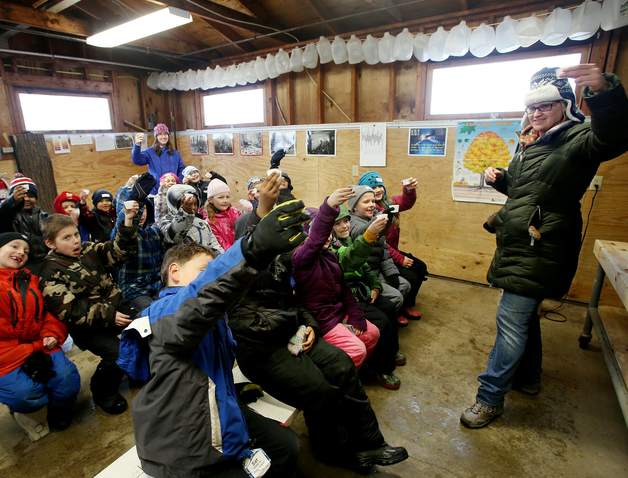 Youth educator Zeta Kilbride (right) of the Minnesota Landscape Arboretum and EXPO Elementary students taste maple sap in the sugarhouse at the Minnesota Landscape Arboretum. ] JOELKOYAMA‚Ä¢jkoyama@startribune Chaska, MN on March 27, 2014. Photo of school kids learning about maple syrup program at the MN Landscape Arboretum. Can you get some shots of kids tasting the syrup? Also, please photograph Richard Devries, who heads the program, preferrably in the sugarhouse.